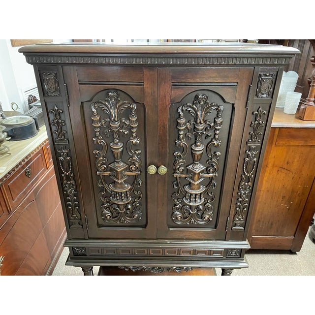 Available for sale is a beautiful walnut wood bar cabinet from the early 1900's. Fully carved throughout with immense...