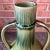 This large, double handled, amphora-shaped vessel in moss green ombré fade glaze with a crackle finish stands 18.25” tall....