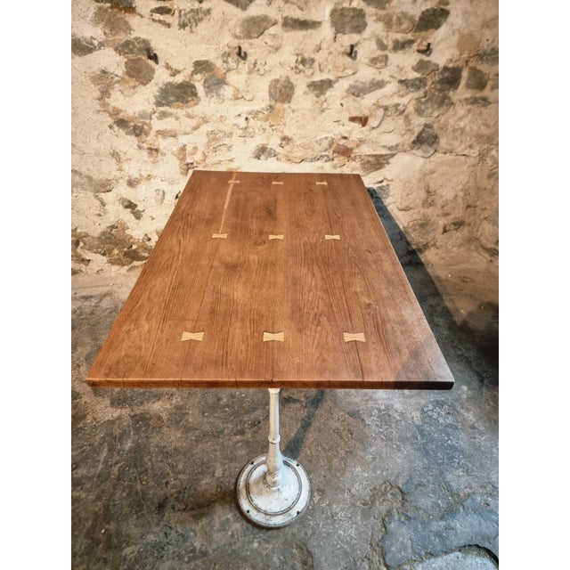 This vintage French oak cast iron table features a solid oak top from the 1950s combined with cast iron bases dating from...