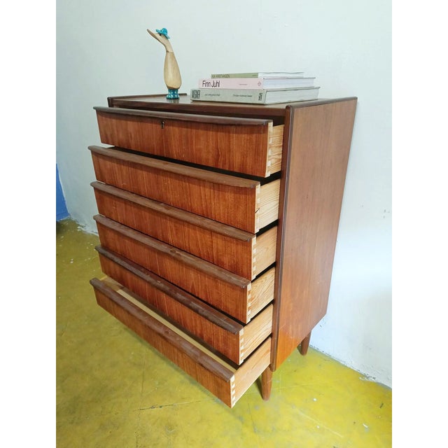 Vintage Danish teak chest of drawers from the 1950s with four drawers and integrated handles, featuring an elegant...