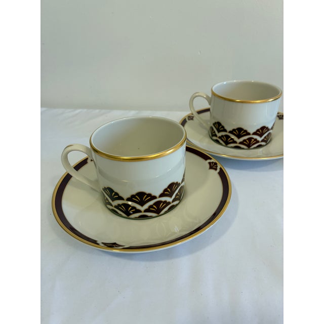 A sophisticated set of four vintage cup and saucer sets by Pickard in the Ensemble Burgundy pattern. Hand decorated in the...