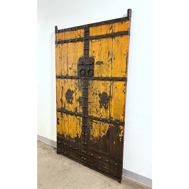 A pair of late 18th century Qing Dynasty Chinese courtyard doors in hand forged iron and painted elm wood (yumu) . These...