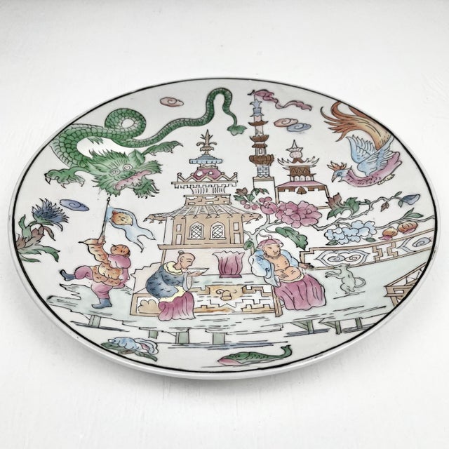 Vintage large chinoiserie decorative plate. Pastel scene with a pagoda temple, dragon, emperors, fish, and peacocks.