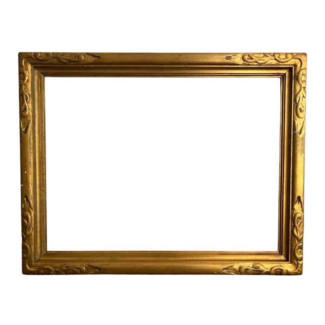 Vintage gold gilt wooden picture frame featuring elegant Art Nouveau-inspired floral and scrolling corner carvings. The...