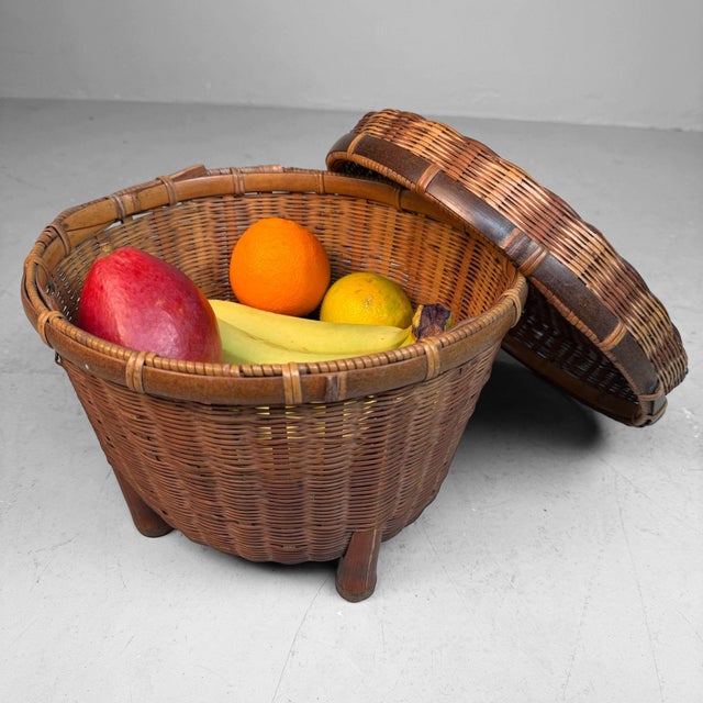 Decorative, handwoven bamboo basket from Japan, resting on four bamboo supports and complete with a matching lid....