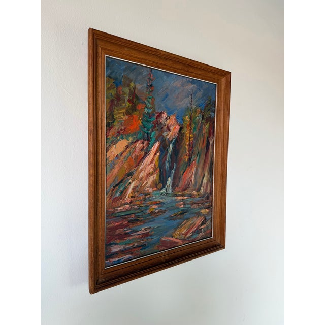 A vibrant 1970s vintage oil on canvas depicting a serene autumn river landscape with cascading waterfalls, rugged rock...