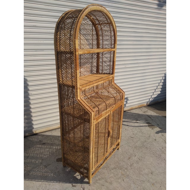 This is a 1970's Boho Chic Bookcase made in Italy. It's made of rattan and bamboo. The top arch has 2 shelves for books....