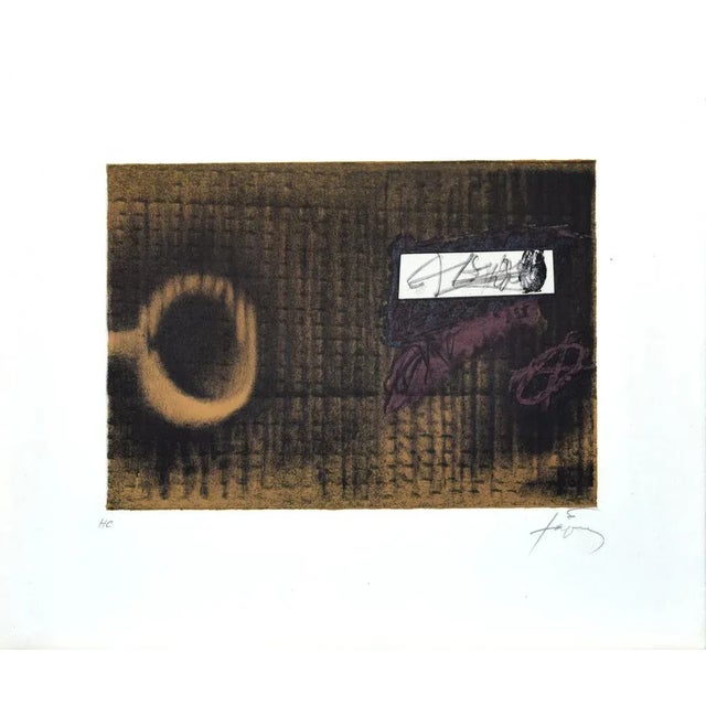 L'Etiquette is an original lithograph realized by the Spanish artist Antoni Tapies. Hand-signed in pencil by the artist on...