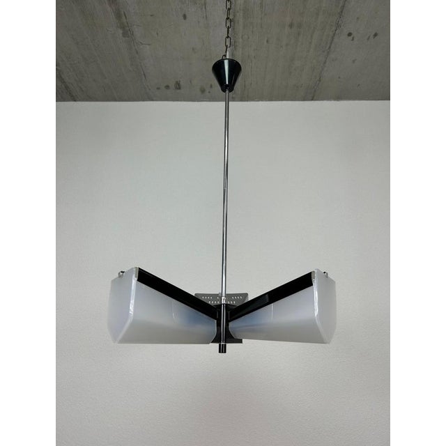 Mid-century design hanging lamp by Lidokov with white plastic lampshades. This piece is attributed to the mentioned...