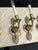 A set of four vintage Empire-style metal sconces with a warm brass finish and single arm design. Elegant and understated,...