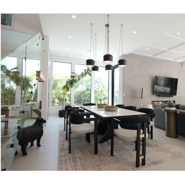 With a curved black wood frame and gold metal details, this chair adds a touch of luxury to any dining space. The black...