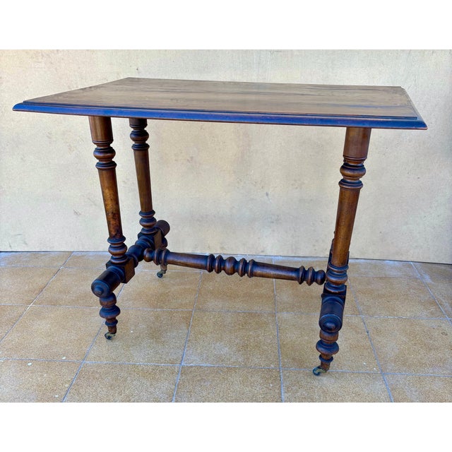 Elegant 20th century side table featuring a beautifully turned-leg base and original castors, typical of late Victorian...