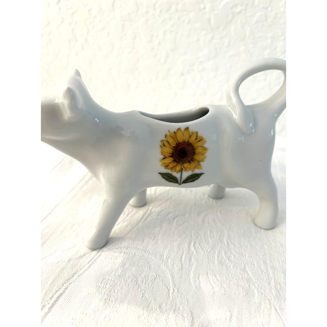 Charming white ceramic cow/bovine creamer featuring a sunflower motif. Excellent condition.