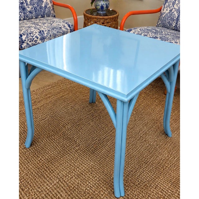 A vibrant and versatile game table, meticulously refinished in a custom high-gloss blue lacquer. This vintage rattan table...