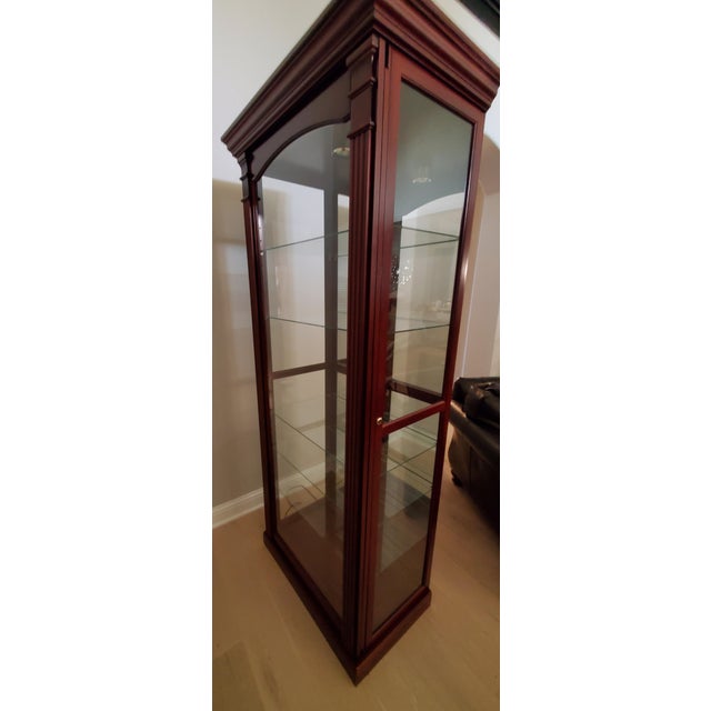 Beautifully crafted, American-made display cabinet by the renowned Pulaski Furniture Corporation. It features a rich,...