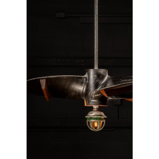 Early 20th-century salvaged ship propeller mold repurposed as a dramatic ceiling-mounted pendant light. Originally created...