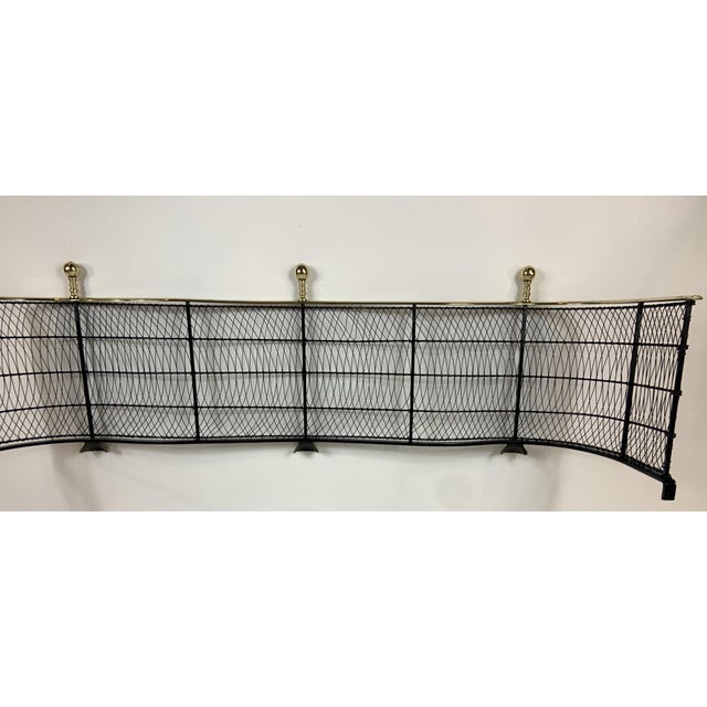 American serpentine brass and wire fire fender with polished brass ball finials and claw feet, c. early 1800s....