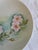 A charming set of two vintage hand-painted floral plates, each signed by the artist and featuring soft pastel botanical...