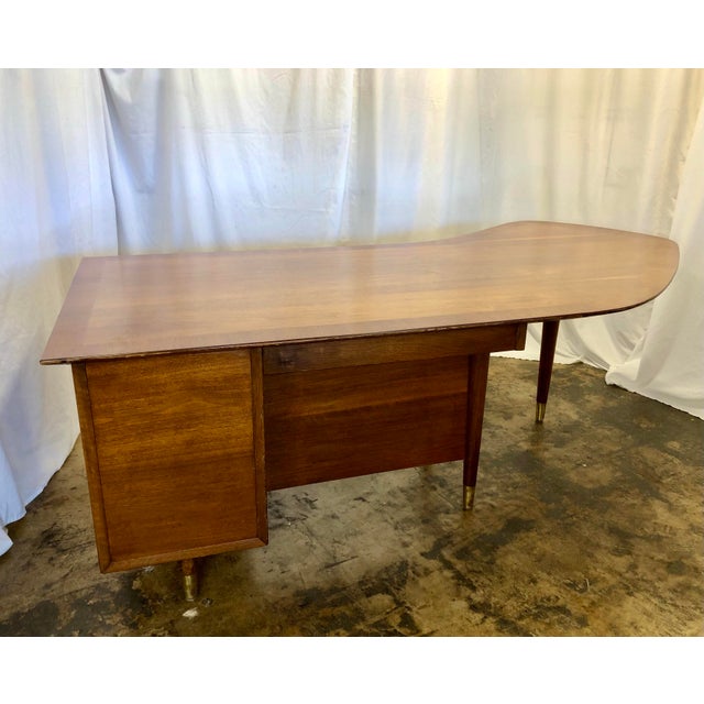 Walnut boomerang desk manufactured by the Standard Furniture Co. The top has 3” border pattern accentuating the boomerang...