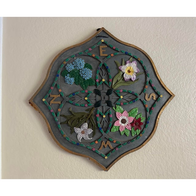 A vintage Gothic Revival wall plaque in a quatrefoil form, featuring sculpted floral reliefs arranged around the cardinal...