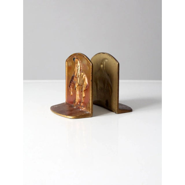 Pair of vintage brass bookends featuring a sculptural interpretation of End of the Trail by James Earle Fraser. The design...