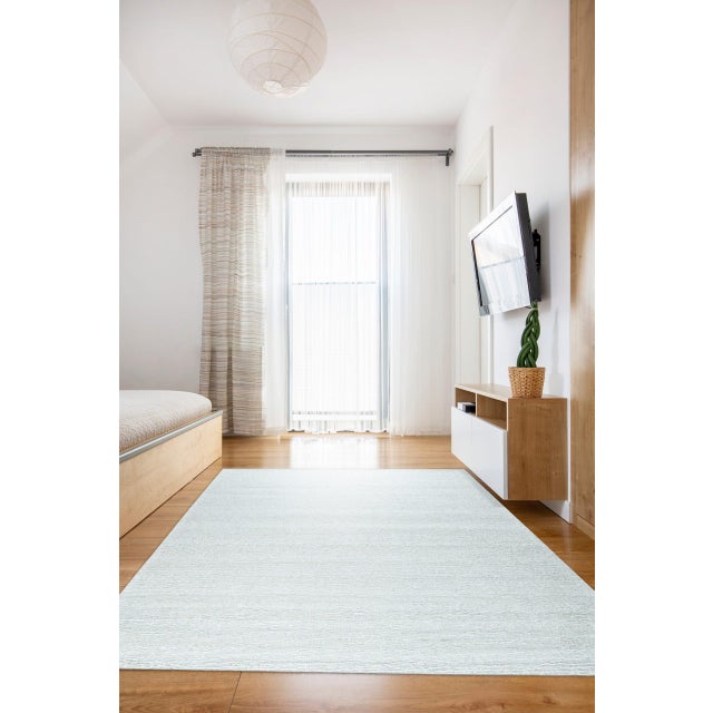 Fiona Rustic Ivory Flatweave Wool Rug, Country of Origin: India. This minimalist piece is a testament to the enduring...