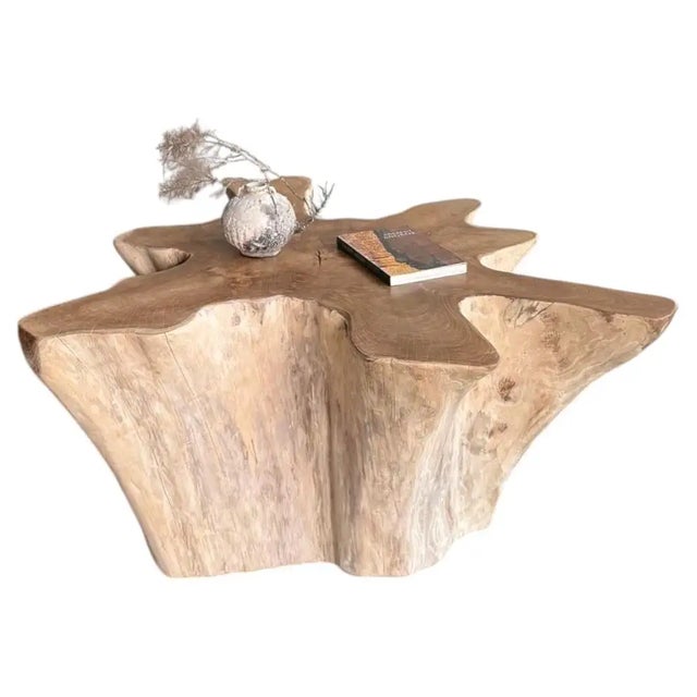 A striking sculptural sofa table carved from a substantial piece of solid teak, distinguished by its dramatic organic...