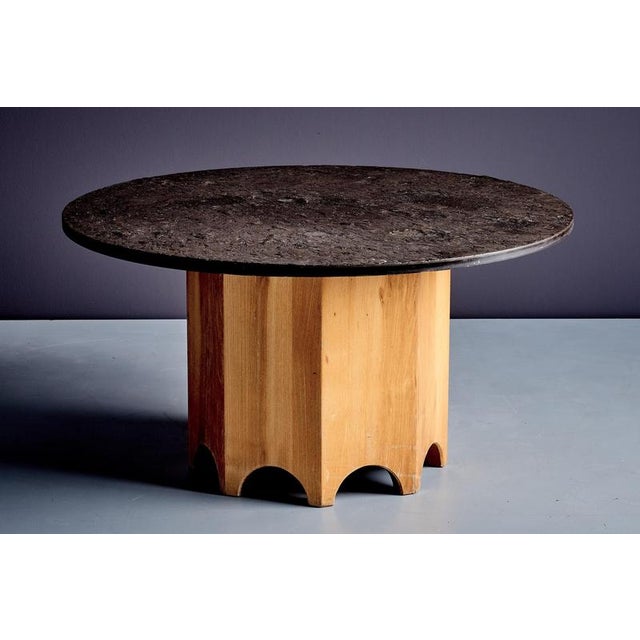 Octagonal pedestal table with a round slate top. The thick stone surface has a rough, naturally mottled texture, set on a...