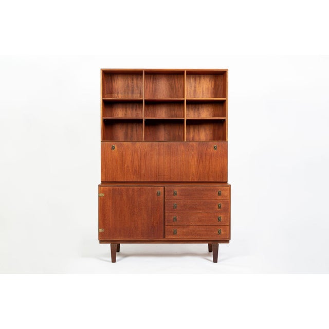 This Danish modern teak secretary bookcase cabinet was designed by Peter Løvig Nielsen and produced by Løvig Dansk Designs...