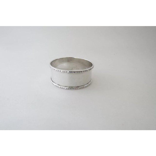 Vintage sterling silver round narrow napkin ring having applied floral rims. Made by Webster. Marked Sterling. The soft,...