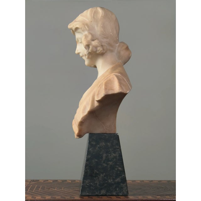 Antique Hand Carved Alabaster Bust of a Young Woman with Marble Stand Description: This art nouveau/neoclassical bust...