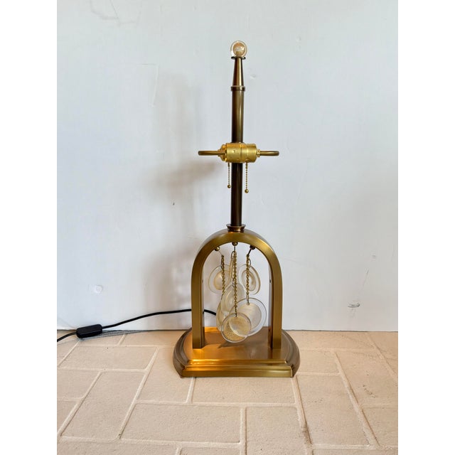 Elegant Baker Laurar Kirar Syro Lamp. Brass color with arched body. Hanging discs with gold speckles. Original Retail...