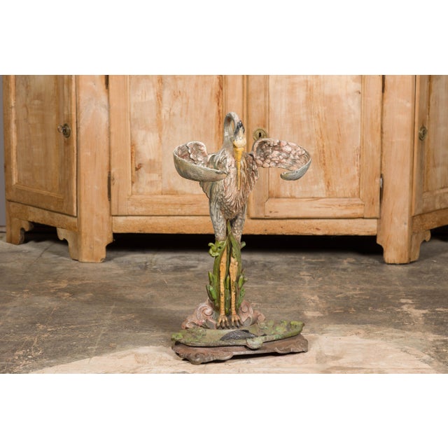This exquisite 19th-century French cast iron heron sculpture, originally crafted as an umbrella stand, embodies a...