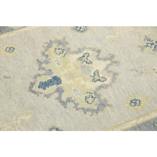 This modern Turkish Oushak rug is a stunning piece of art that has been handwoven using traditional techniques by skilled...