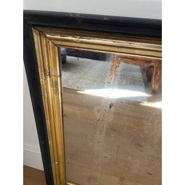 A beautifully aged antique wall mirror featuring a warm gilt-finish frame and wonderfully timeworn mirrored glass. The...