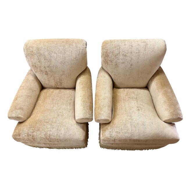 A luxurious pair of generously proportioned lounge chairs upholstered in a softly textured champagne-gold chenille fabric...