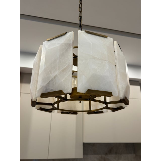 Three RH Harlow pendants made from translucent calcite that is cut in sheer and faceted slabs, each held in place by a...