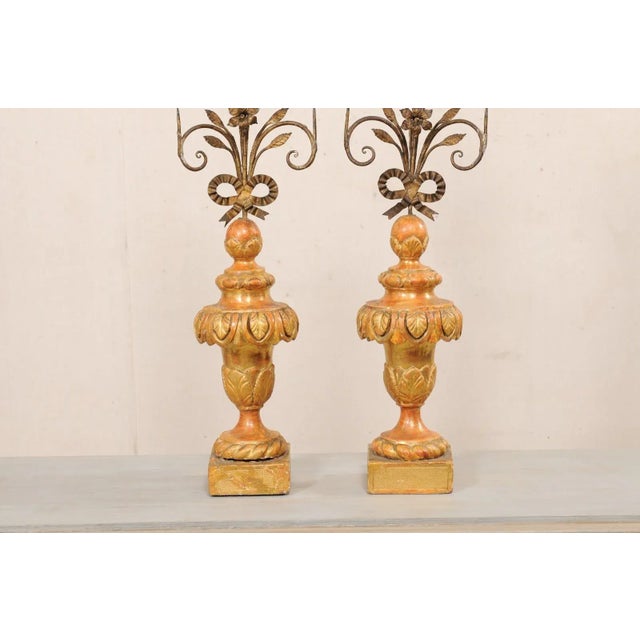 An Italian pair of hand-forged floral iron pricketts on carved wood bases, with their original painted finish, from the...