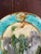 French majolica commemorative plate with relief-molded center depicting Joan of Arc before a fortified tower, holding her...