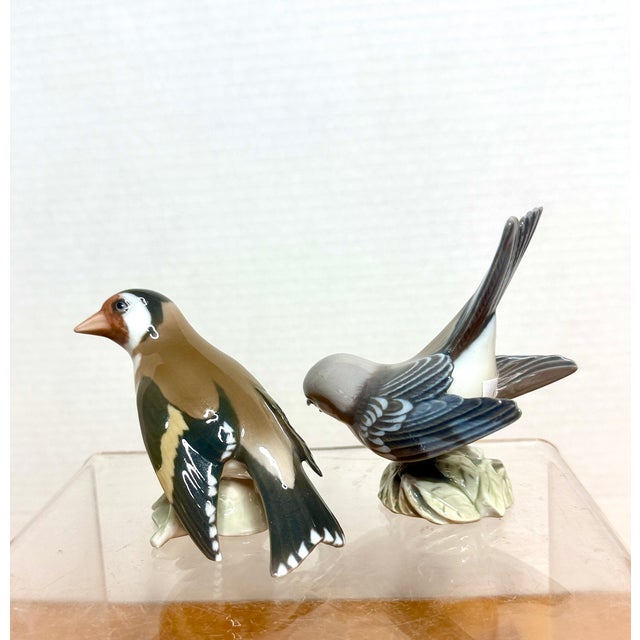 Vintage porcelain figurines are Danish bird sculptures from the manufacturer Bing & Grøndahl. The figurine on the left is...