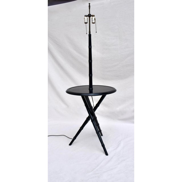 A mid-20th century black lacquered faux bamboo table with lamp, the upright stem & lamp being supported upon tripod base...
