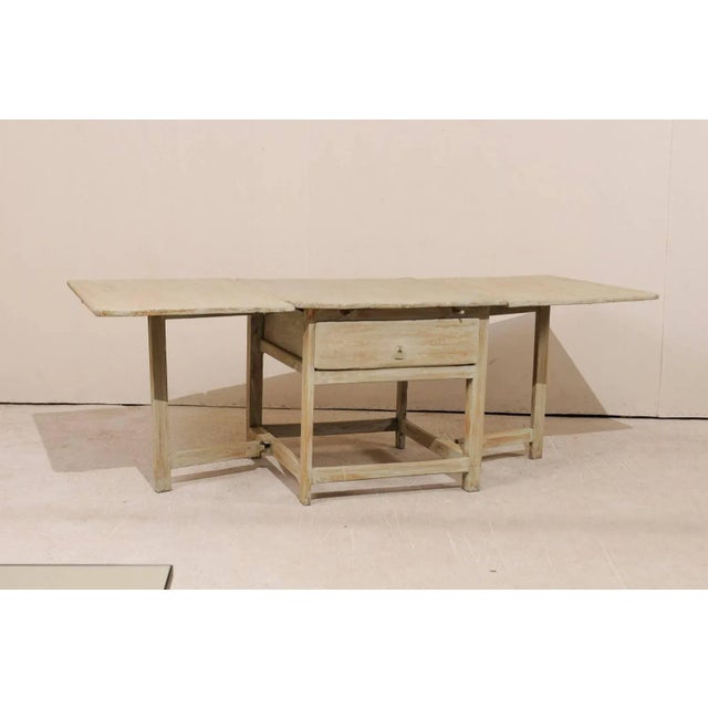 A Swedish 18th century painted wood drop leaf table with gate-leg. This 18th century Swedish rustic farmhouse style table...