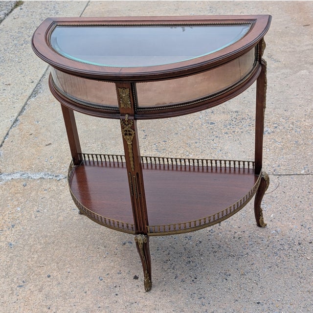 Elevate your collection with this exquisite late 19th-century French demilune vitrine, expertly crafted from rich mahogany...