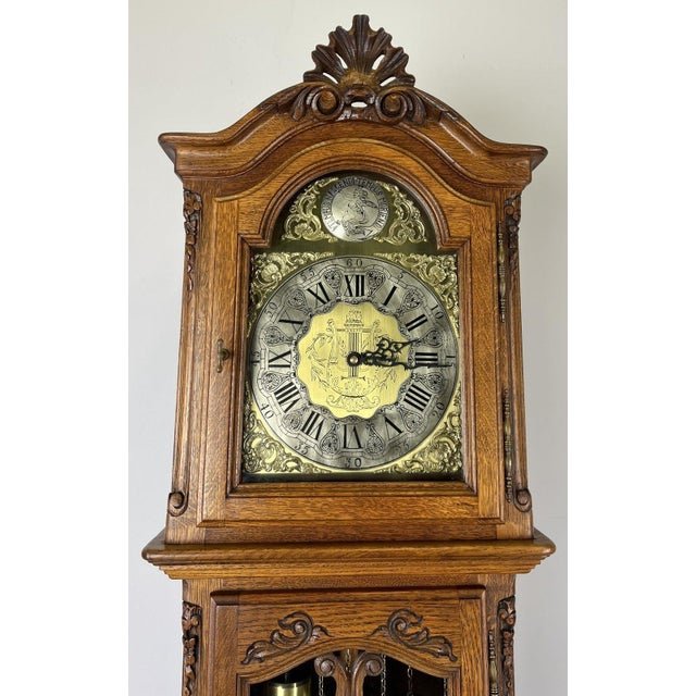 An impressive Vintage French grandfather clock crafted from oak with beautifully carved detailing and a classic longcase...