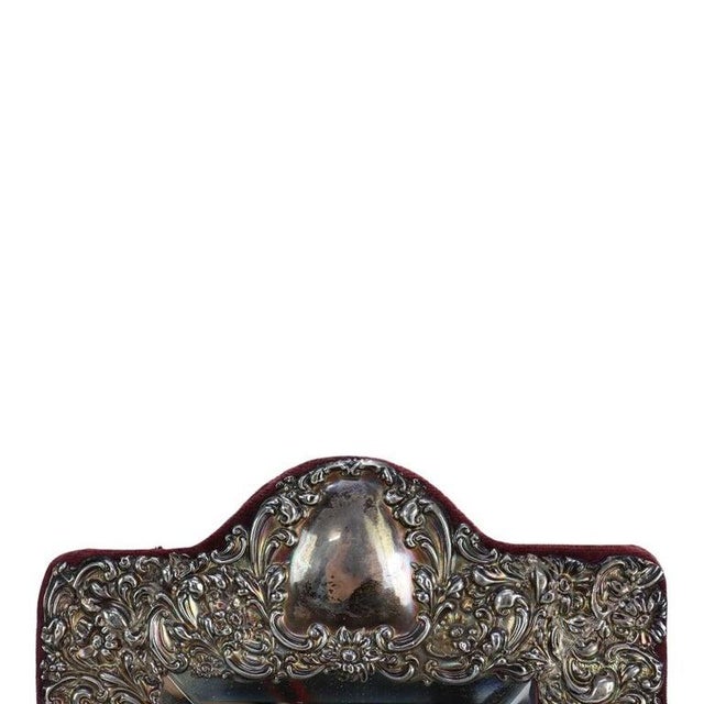 An exquisite antique Victorian dresser mirror, crafted from sterling silver with a rich floral repousse embossed design....