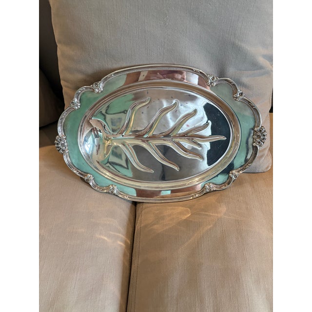 This highly ornate footed oval/elliptical serving tray boasts a distinctly traditional, formal design with a dramatically...