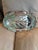 This highly ornate footed oval/elliptical serving tray boasts a distinctly traditional, formal design with a dramatically...