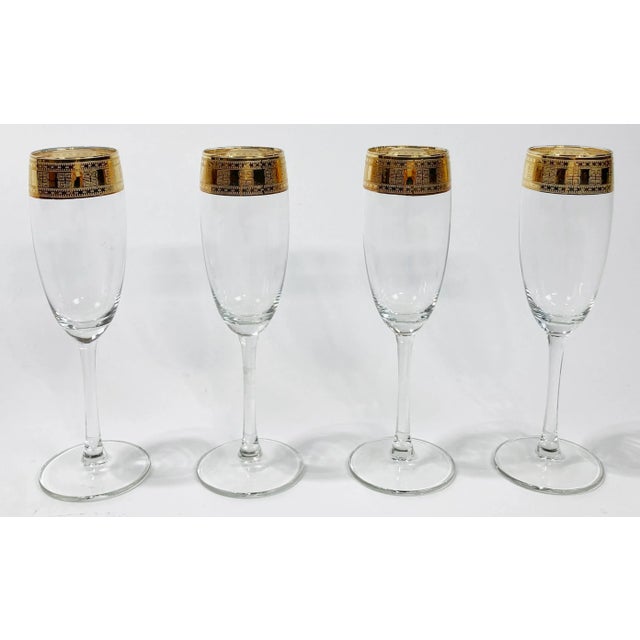 Set of 4 vintage champagne glasses featuring 22k Greek key pattern gold rims. Minor wear to gold rims per use. No chips or...