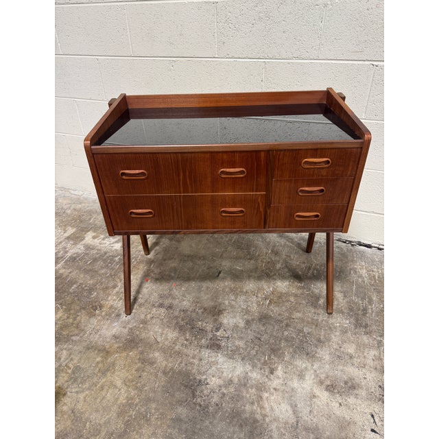 This is a great piece! Black glass top teak with drawers. Couple of small catchall trays included. Check the dimensions....