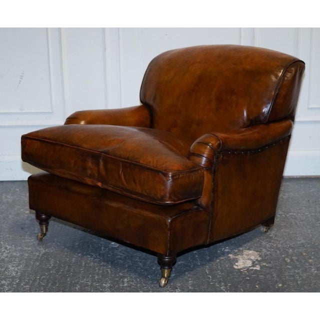 Antiques of London A stunning pair of large Howard-style armchairs, upholstered in richly hand-dyed leather and fitted...